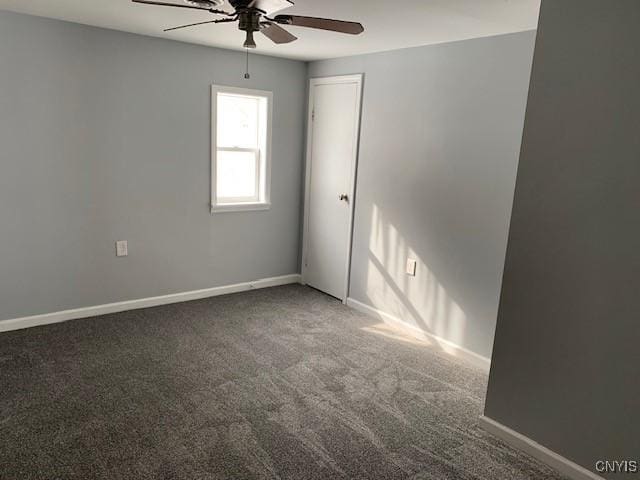 empty room with dark carpet, baseboards, and ceiling fan