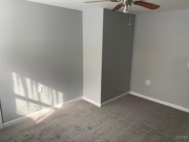 carpeted spare room with ceiling fan and baseboards