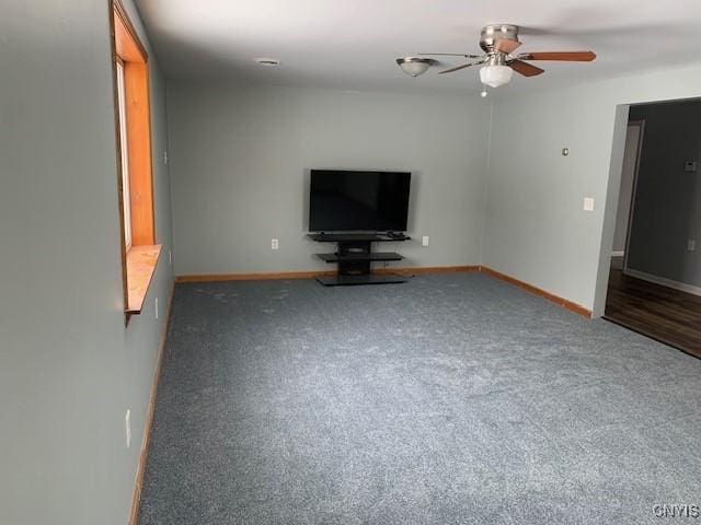 unfurnished living room with carpet floors, a ceiling fan, and baseboards