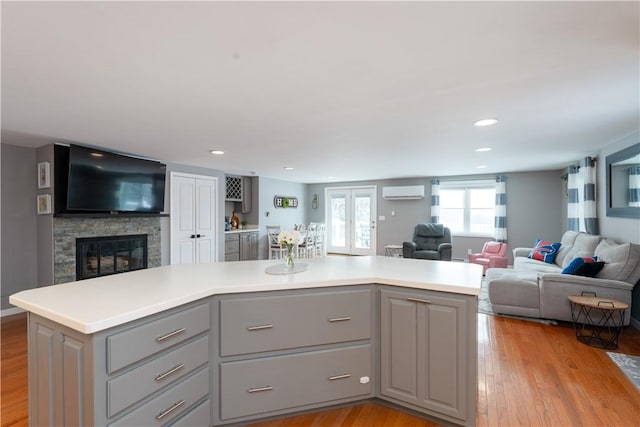 kitchen with open floor plan, a center island, light countertops, gray cabinetry, and light wood-style floors