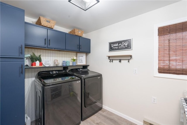 laundry area featuring a baseboard radiator, separate washer and dryer, baseboards, cabinet space, and light wood finished floors