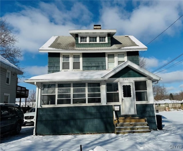 american foursquare style home with a sunroom and a chimney