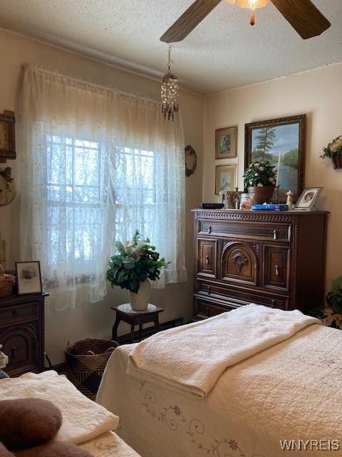 bedroom featuring ceiling fan and a textured ceiling