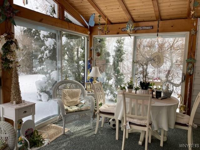 sunroom / solarium featuring wood ceiling and lofted ceiling with beams