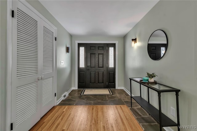 entrance foyer with visible vents, baseboards, and dark wood finished floors