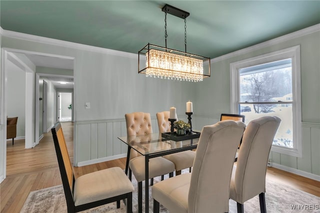 dining space with light wood-type flooring, plenty of natural light, and crown molding