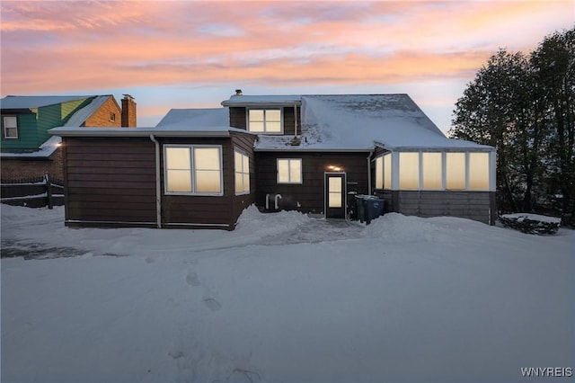 view of snow covered rear of property