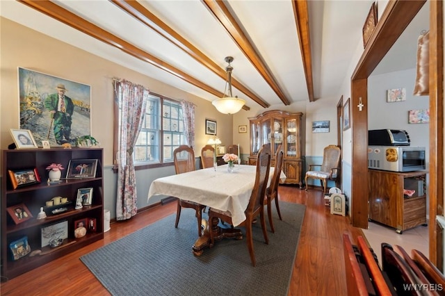 dining room featuring wood finished floors and beam ceiling