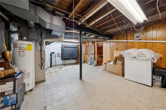 unfinished below grade area featuring wood walls, gas water heater, and tile patterned floors