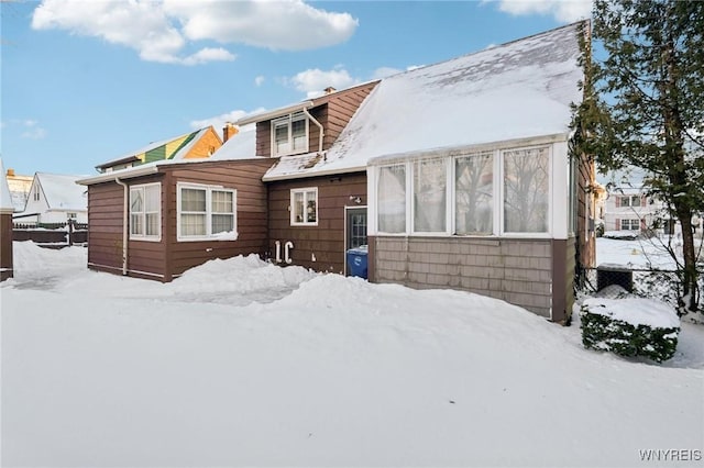 snow covered house with fence