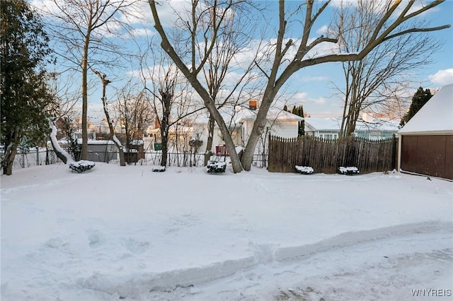 snowy yard featuring fence