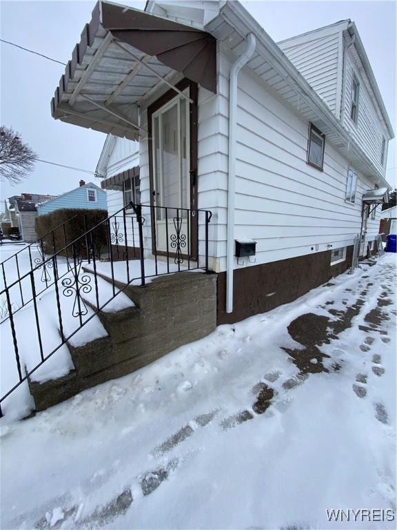 view of snow covered exterior featuring fence