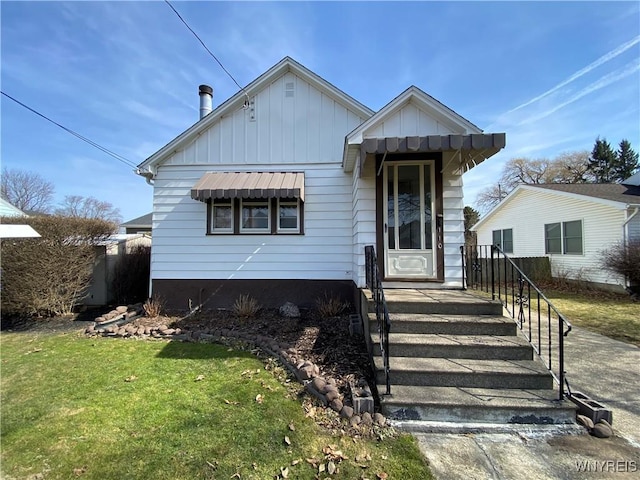 bungalow-style home featuring board and batten siding and a front lawn