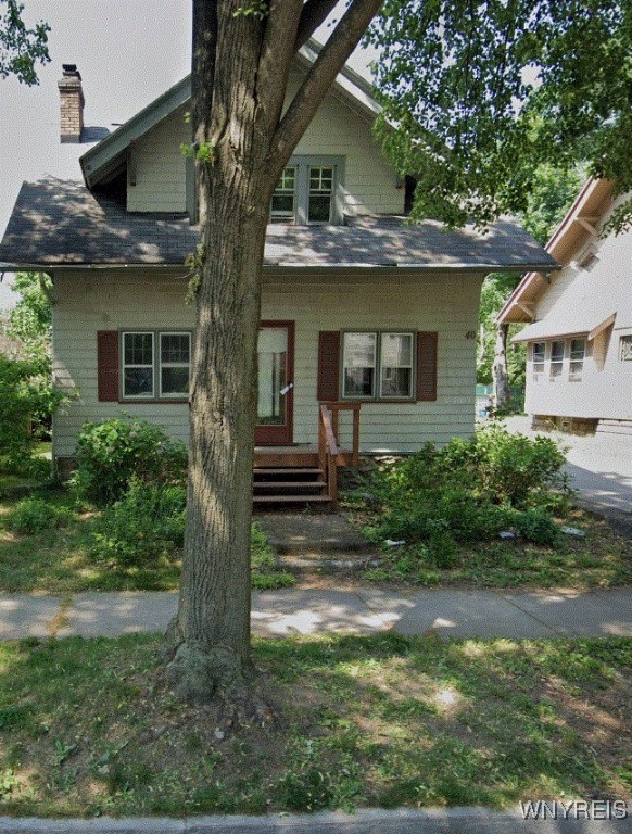 view of front of house with entry steps and a chimney