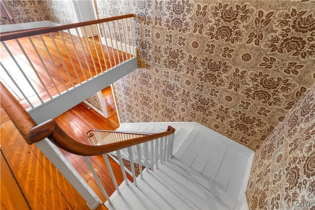 staircase with wallpapered walls