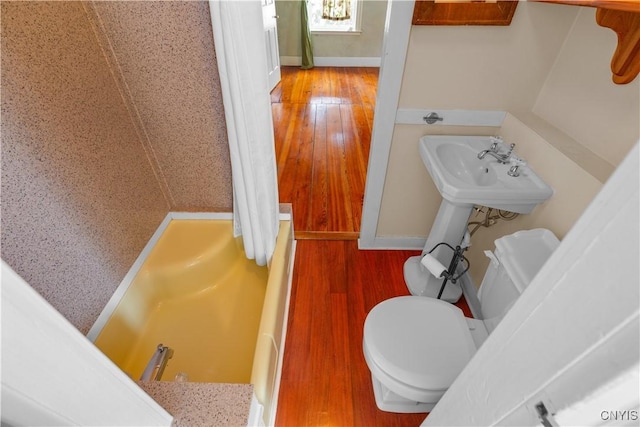 bathroom featuring wood finished floors, toilet, and baseboards