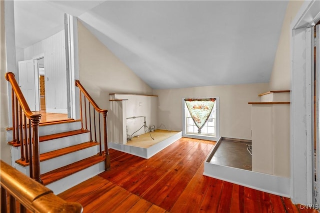 interior space featuring stairs, wood finished floors, and lofted ceiling