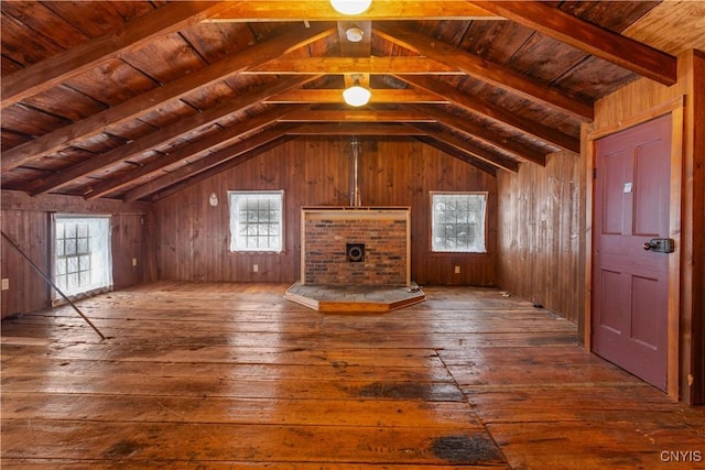 unfurnished living room featuring wood walls, wooden ceiling, wood finished floors, and a wealth of natural light