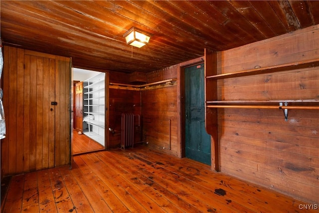 unfurnished bedroom featuring wooden ceiling, wood walls, and wood finished floors