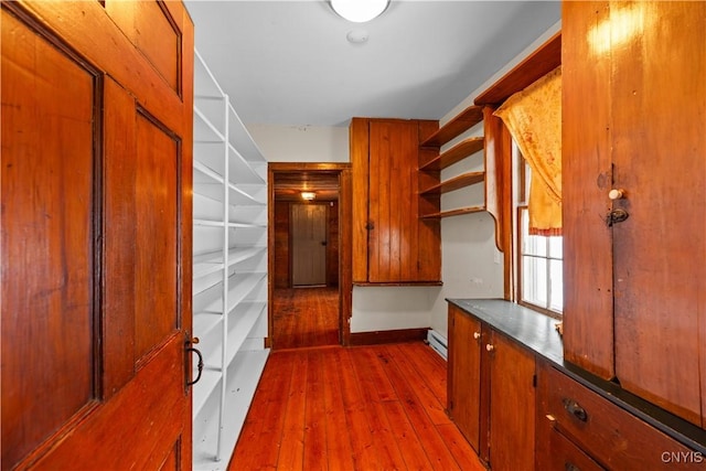 hallway with a baseboard radiator and wood finished floors