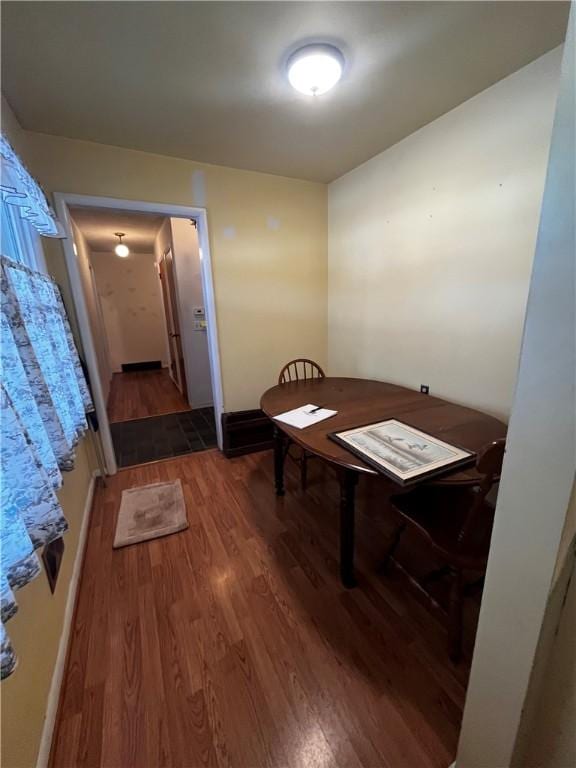 dining room featuring dark wood-type flooring and baseboards