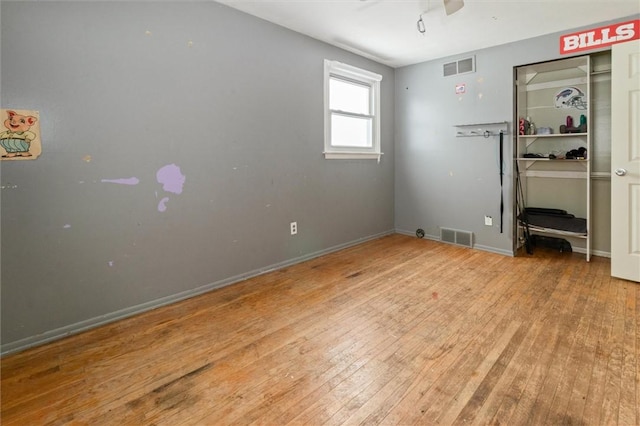 unfurnished bedroom featuring baseboards, visible vents, and light wood finished floors