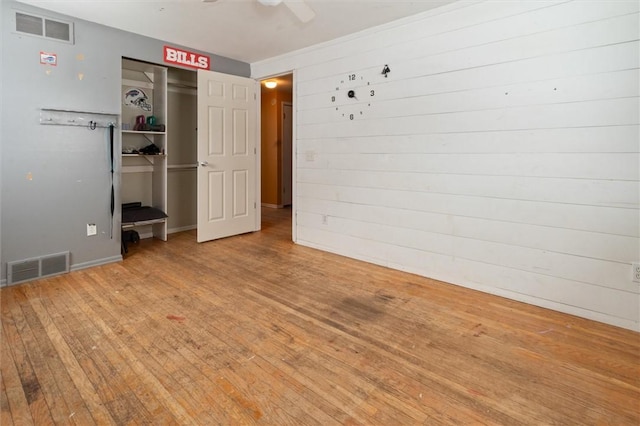 unfurnished bedroom with a ceiling fan, a closet, visible vents, and wood finished floors