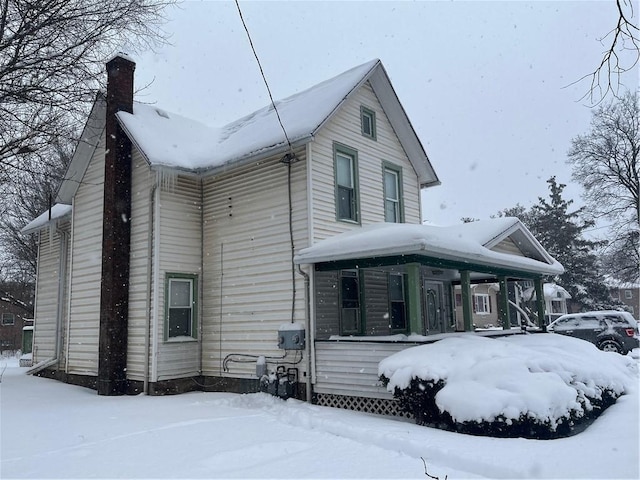 view of front of home featuring a porch and a chimney