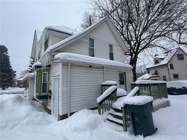 view of snow covered exterior with a garage