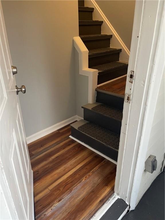 staircase with baseboards and wood finished floors