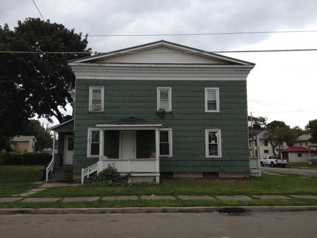 view of front of house featuring covered porch and a front lawn