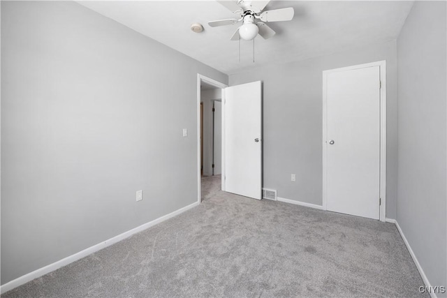 unfurnished bedroom with visible vents, baseboards, a ceiling fan, and light colored carpet