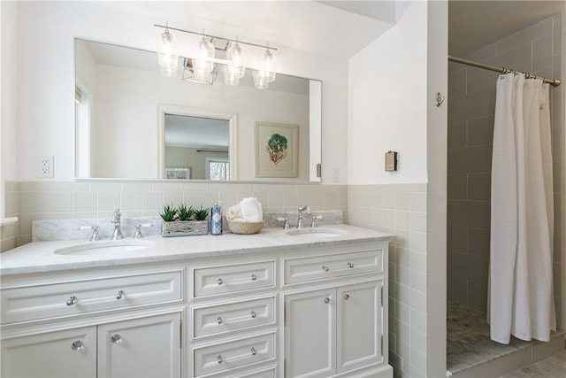 bathroom featuring double vanity, a sink, and tiled shower