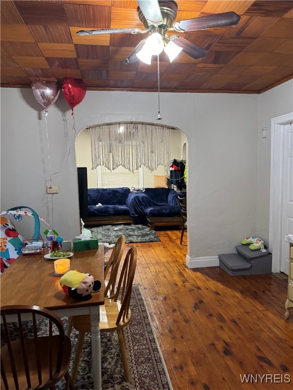 dining room with arched walkways, wooden ceiling, ceiling fan, and wood finished floors