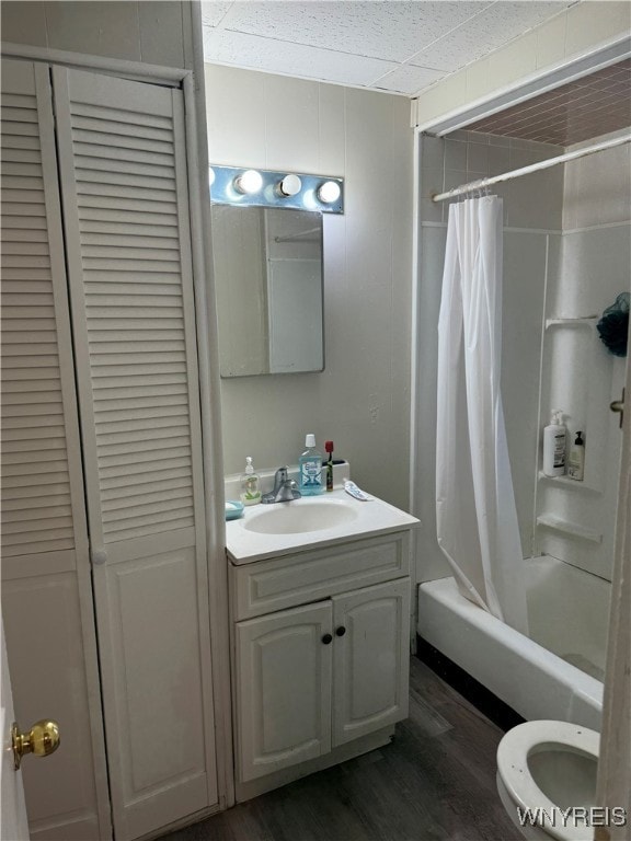 bathroom featuring toilet, wood finished floors, vanity, a closet, and shower / bath combo