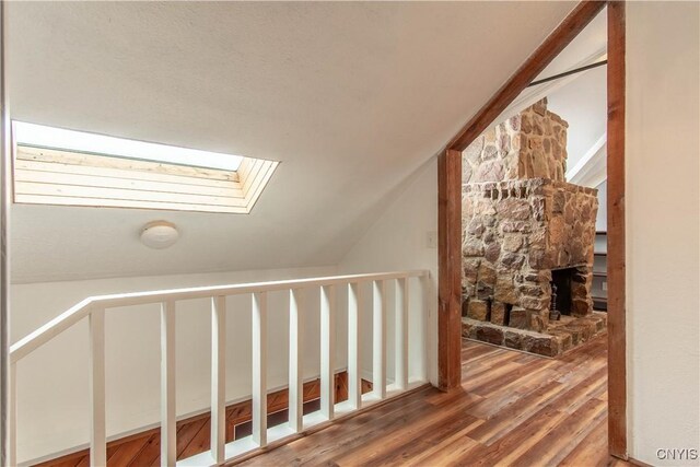 32702 Old Town Springs Rd, Clayton, NY 13622 - corridor featuring vaulted ceiling with skylight and wood finished floors