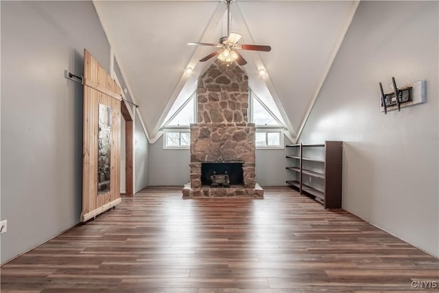 32702 Old Town Springs Rd, Clayton, NY 13622 - unfurnished living room featuring ceiling fan, wood finished floors, vaulted ceiling, and a stone fireplace