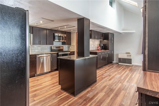 32702 Old Town Springs Rd, Clayton, NY 13622 - kitchen featuring baseboards, light wood finished floors, light stone countertops, and appliances with stainless steel finishes