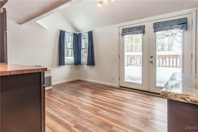 32702 Old Town Springs Rd, Clayton, NY 13622 - unfurnished dining area with baseboards, lofted ceiling, light wood-style flooring, and french doors