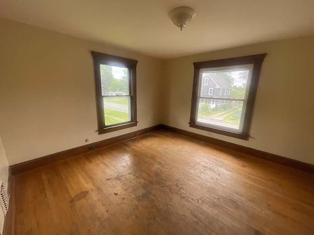 spare room featuring baseboards and wood finished floors