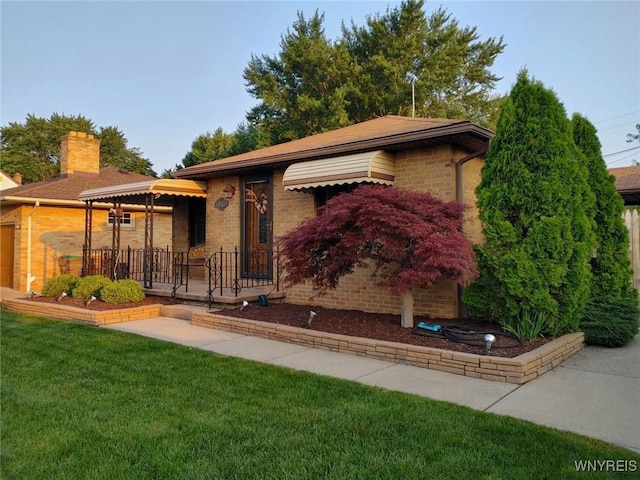 view of front of home with brick siding and a front yard