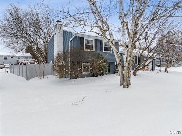 view of front of home featuring a chimney and fence