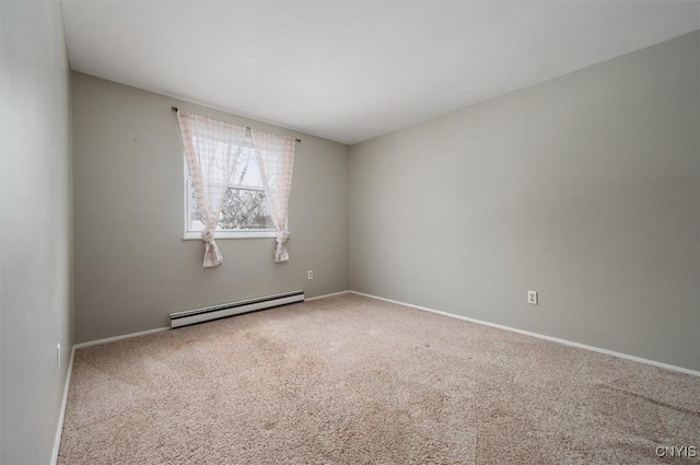 carpeted empty room featuring a baseboard heating unit and baseboards