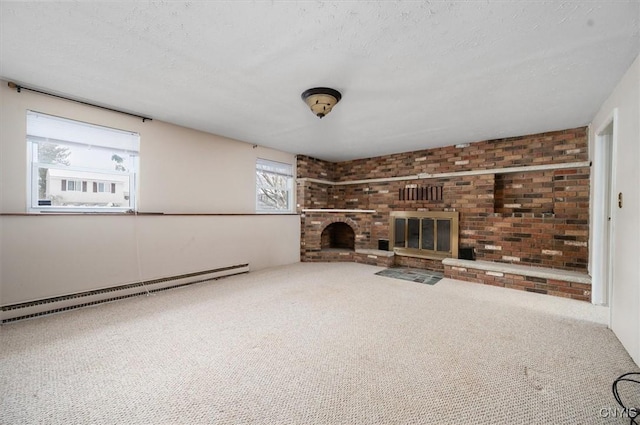 unfurnished living room with a textured ceiling, carpet, a baseboard radiator, and a brick fireplace