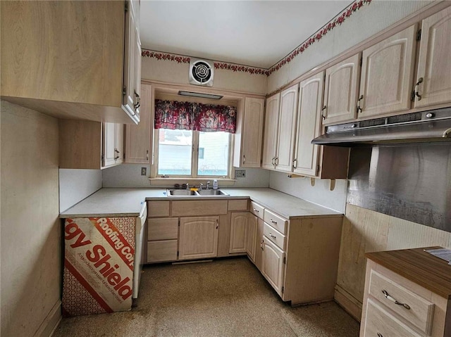 kitchen featuring light countertops, a sink, under cabinet range hood, and light brown cabinets