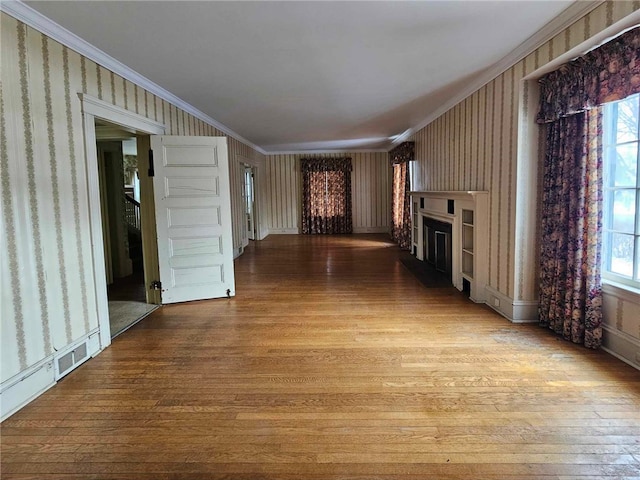 unfurnished living room featuring wallpapered walls, light wood-style floors, a fireplace, and crown molding