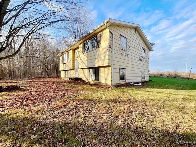 view of property exterior with a lawn