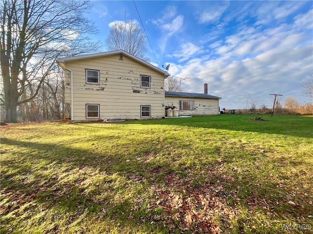 rear view of property with a lawn