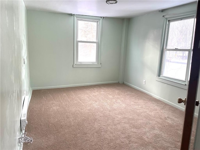 carpeted empty room featuring a wealth of natural light and baseboards