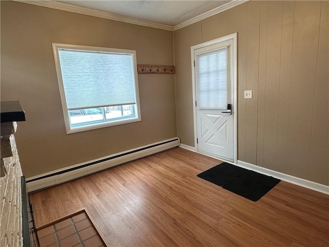 entryway featuring light wood-style flooring, a baseboard heating unit, baseboards, and ornamental molding